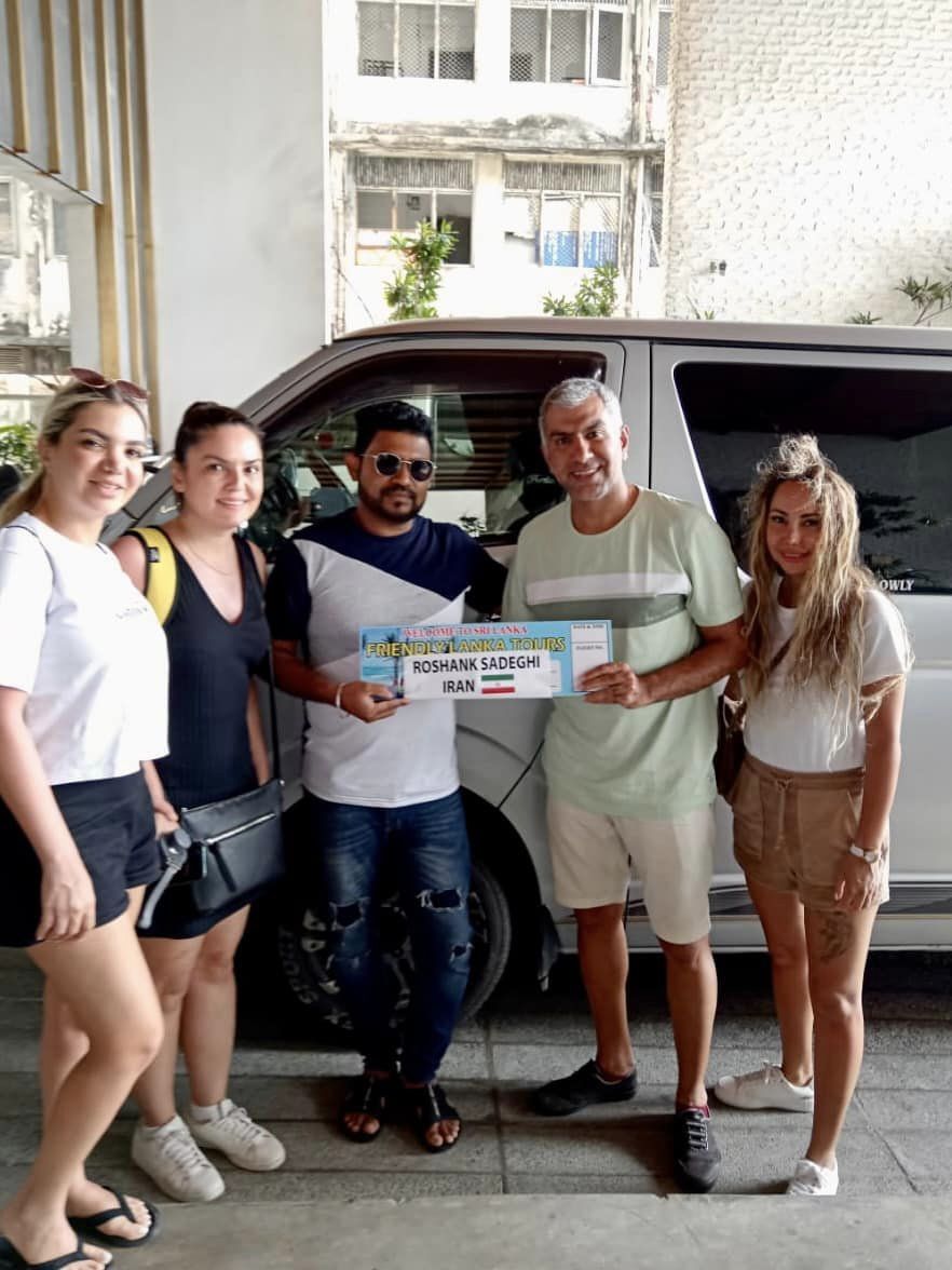 A group posing together beside a tour van