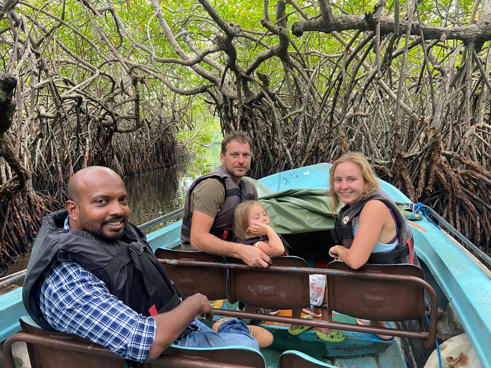 Travellers taking a boat through mangroves