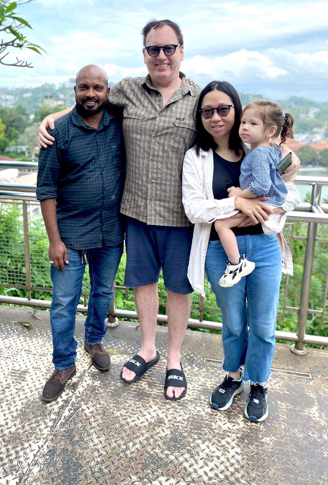 A group posing at a viewpoint overlooking green hills
