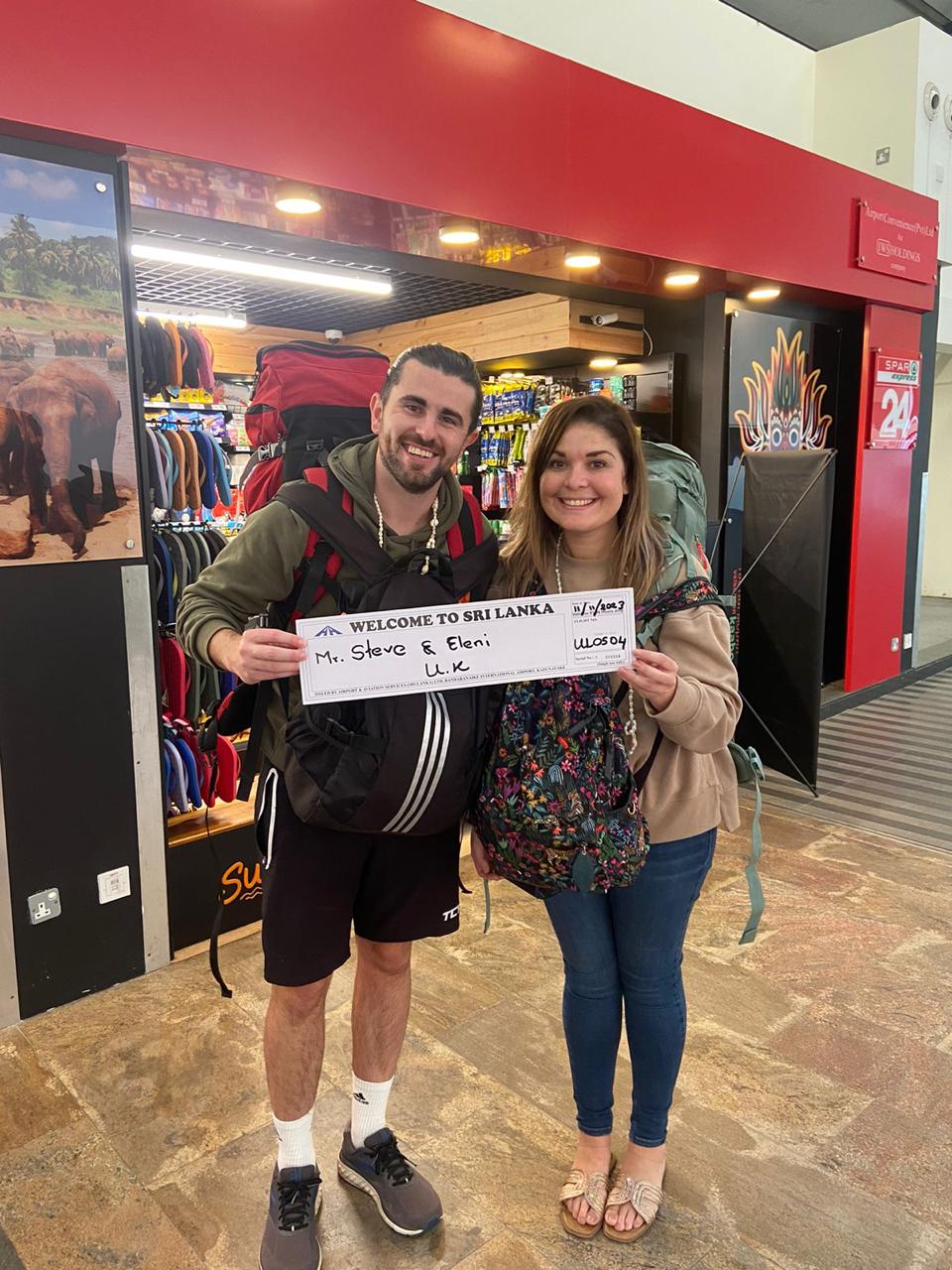Travellers posing together with a welcome sign