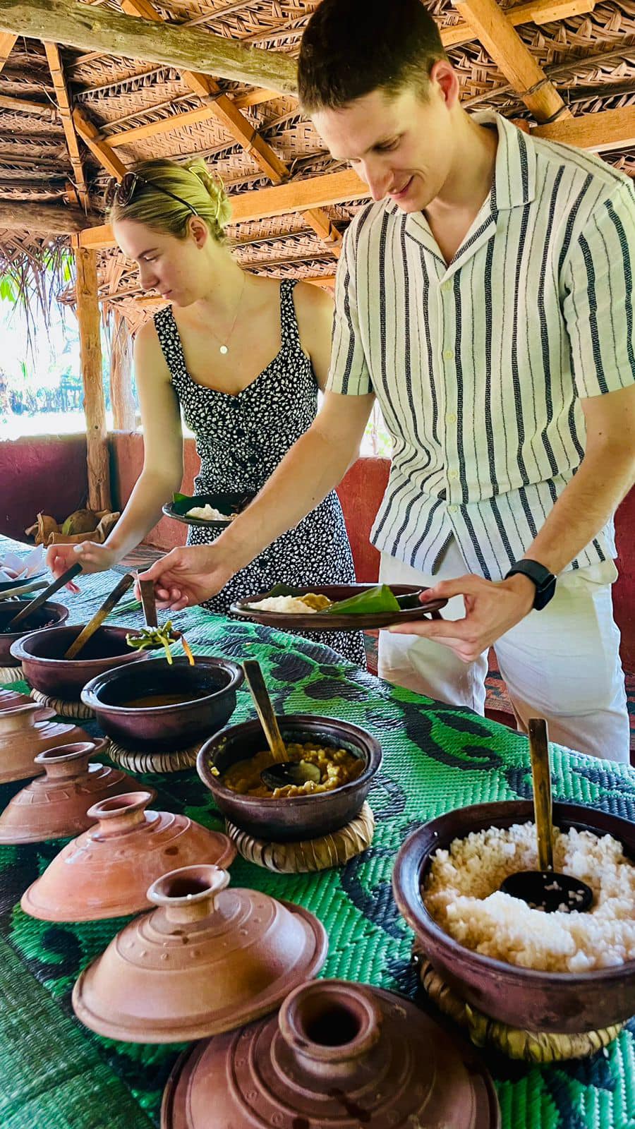 A visitor exploring a spread of traditional Sri Lankan food