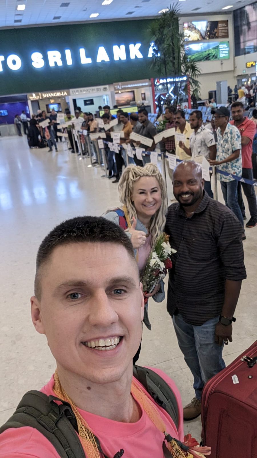 A group selfie in an airport arrival hall