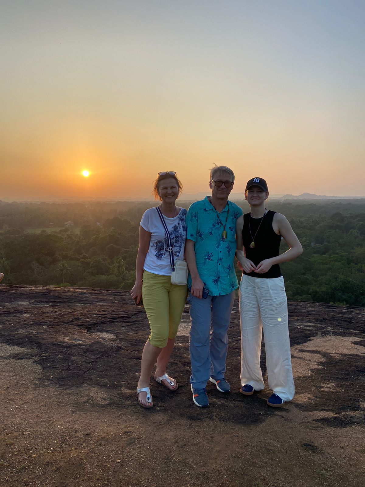 Travellers enjoying sunset at a rocky viewpoint